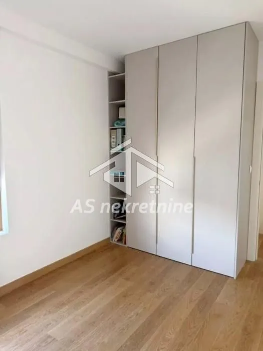 Bedroom with a built-in wardrobe and wooden flooring.