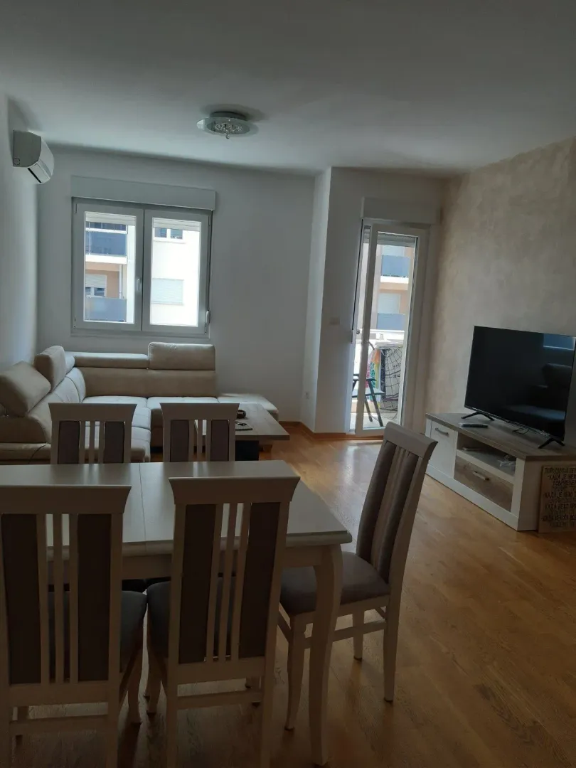 Bright living room featuring a dining table and corner sofa.