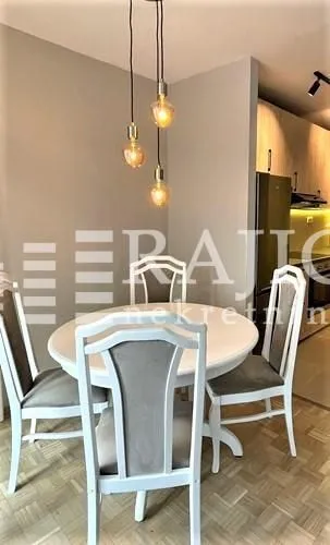 Dining area with a round table and chairs in a modern apartment.
