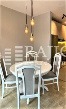 Dining area with a round table and chairs in a modern apartment. - image 9