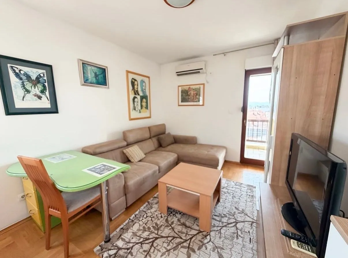 Living room with sofa, dining table, and access to the terrace.