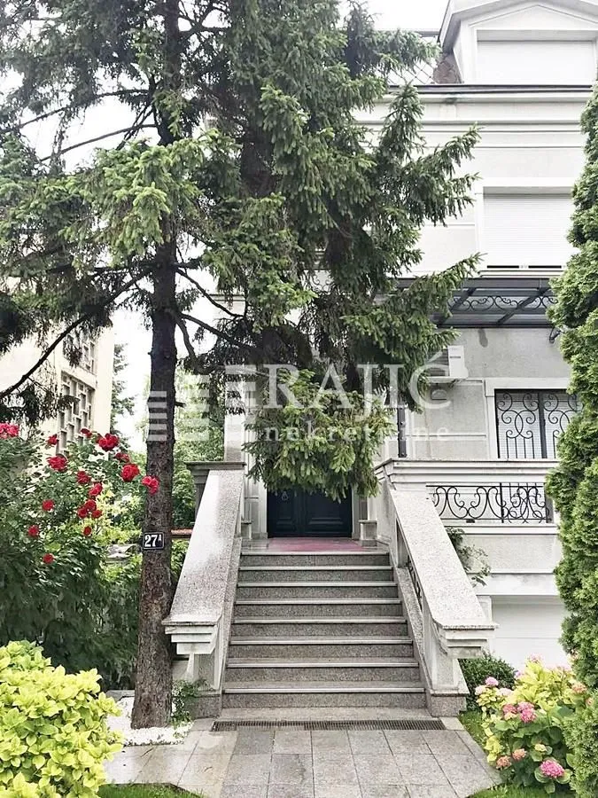Entrance to the house with stairs and landscaped yard.