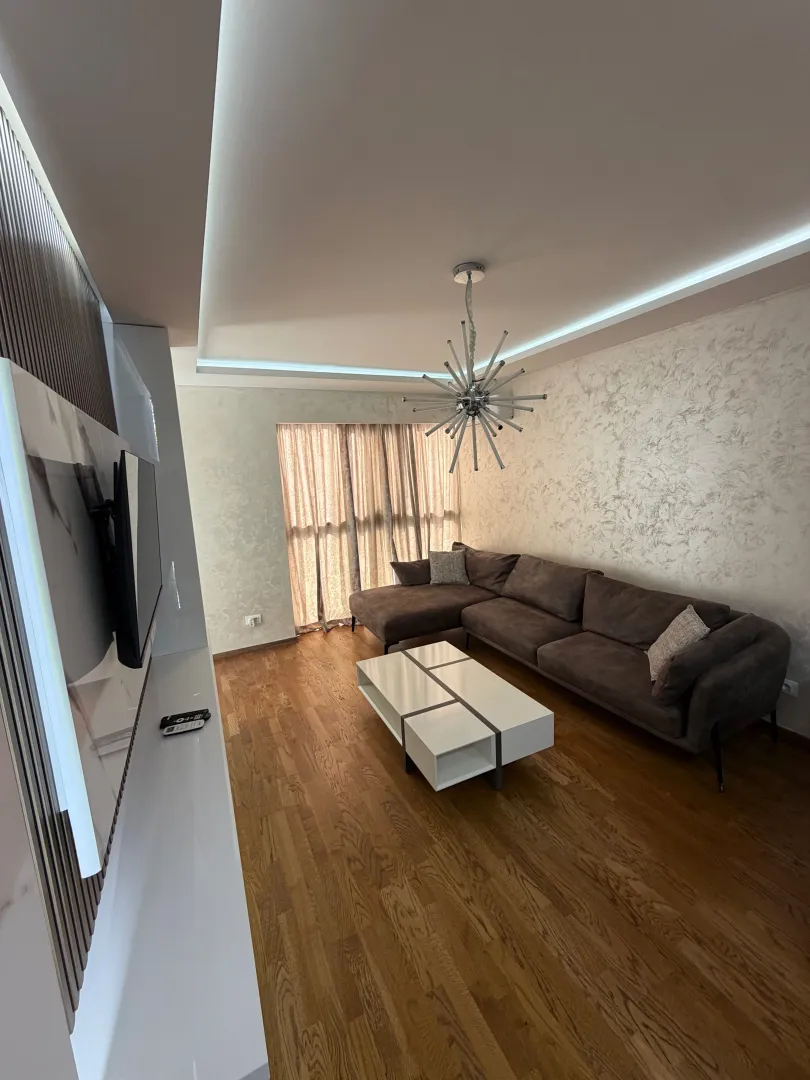 Living room with a sectional sofa, coffee table and TV.