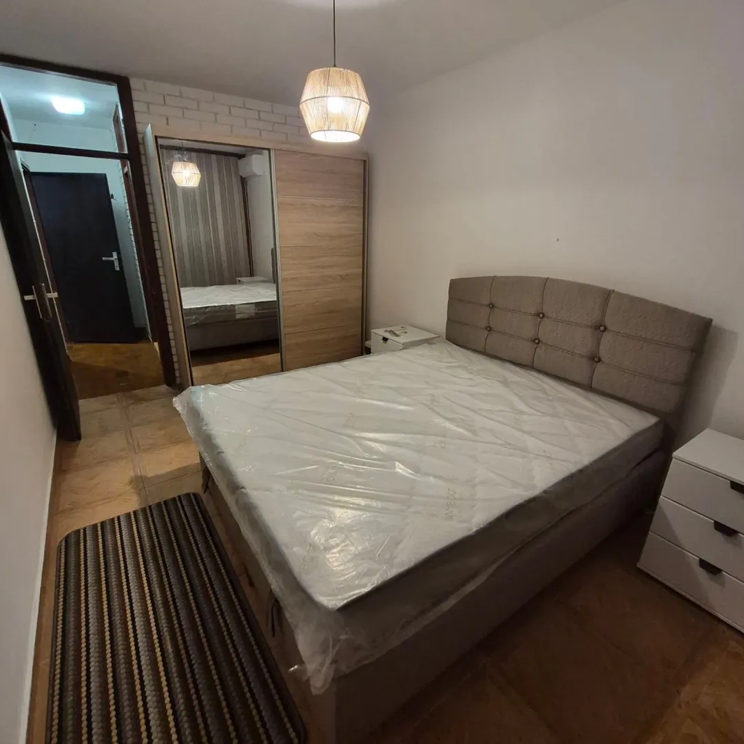 Furnished bedroom with a double bed, wardrobe, and nightstand.