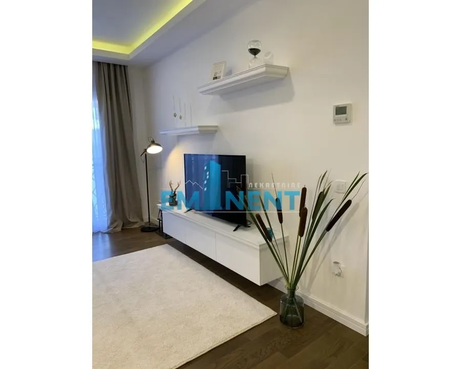 Living room with a TV unit, shelves, and decorative elements.