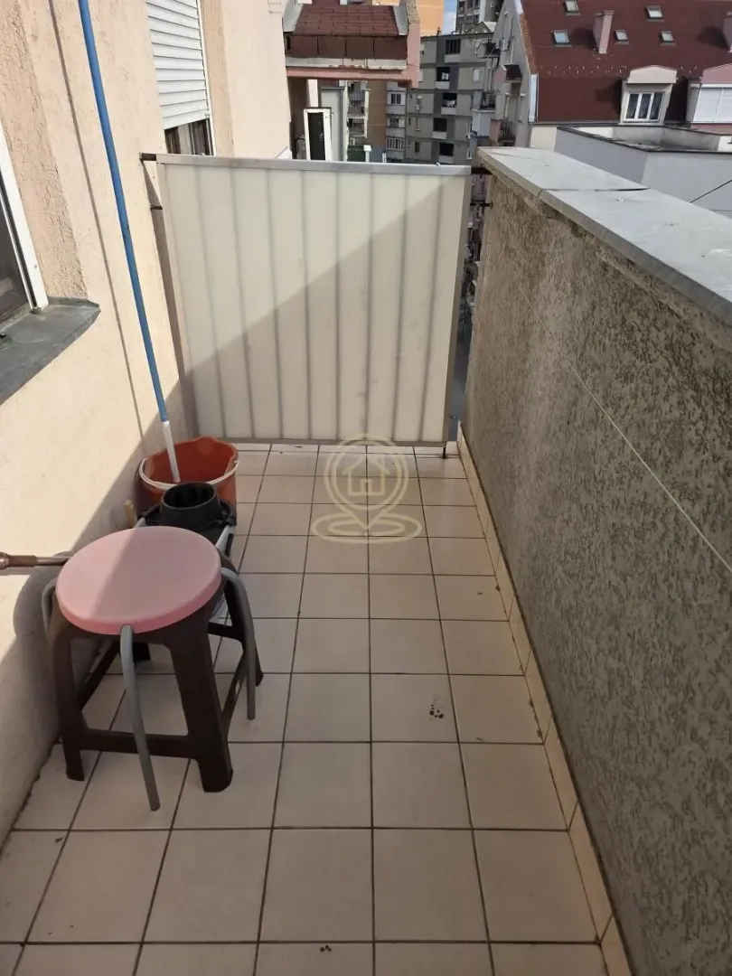 Pogled na prostrani balkon sa keramičkim pločicama i ogradom.