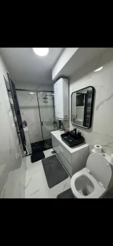 Moderne kupatilo sa tuš kabinom i crnim umivaonikom. - image 11