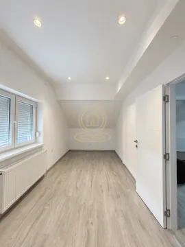 Prazna soba sa laminatom, belim zidovima i prozorom. - image 3