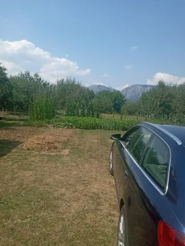 Prostrano dvorište sa zelenilom i pogledom na planine u daljini. - image 9