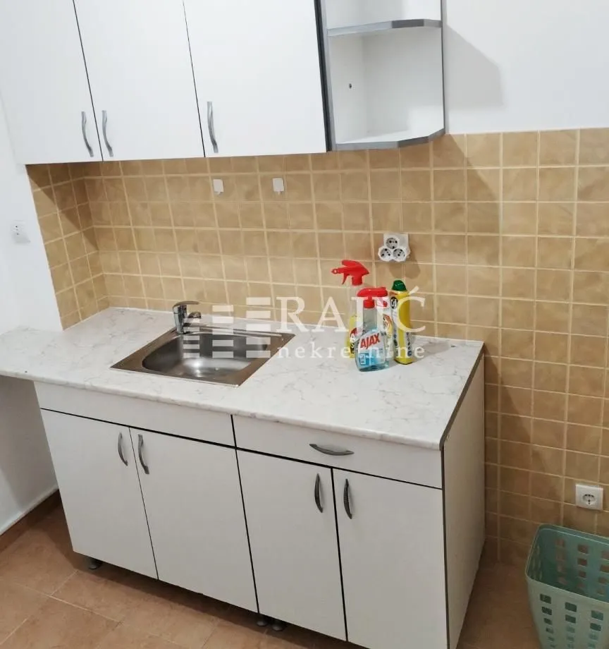 Small kitchen with white cabinets and a sink.