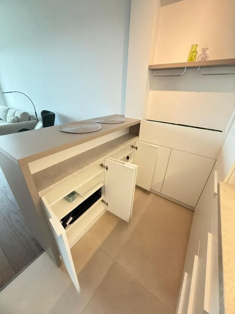 Modern kitchen with built-in cabinetry and open shelving.