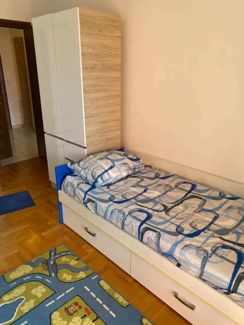 Dječija soba sa krevetom i ormarom.