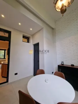 Dining area with a round table and chairs next to a white brick wall. - image 17