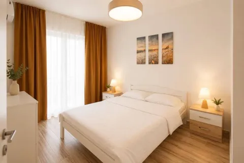 A furnished bedroom with a double bed, bedside tables, and a window with yellow curtains. - image 5