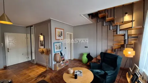 Dnevna soba sa foteljom, stočićem i stepeništem koje vodi na gornji sprat. - image 20