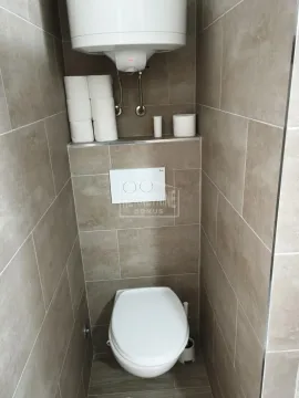 Pogled na kupatilo sa pločicama u braon tonovima i ugradnom šoljom. - image 10