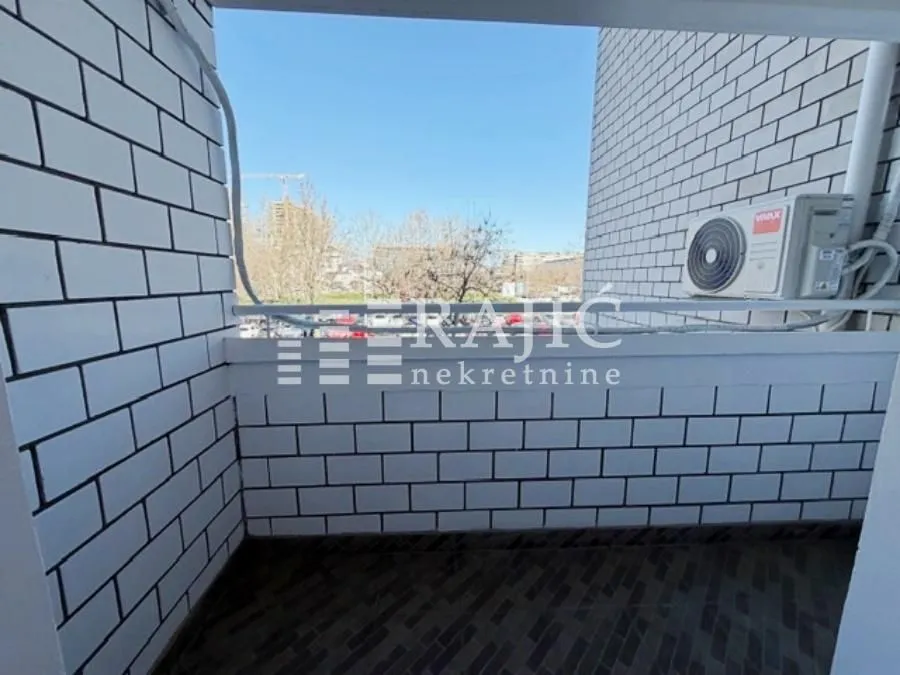 Small tiled balcony with a city view.