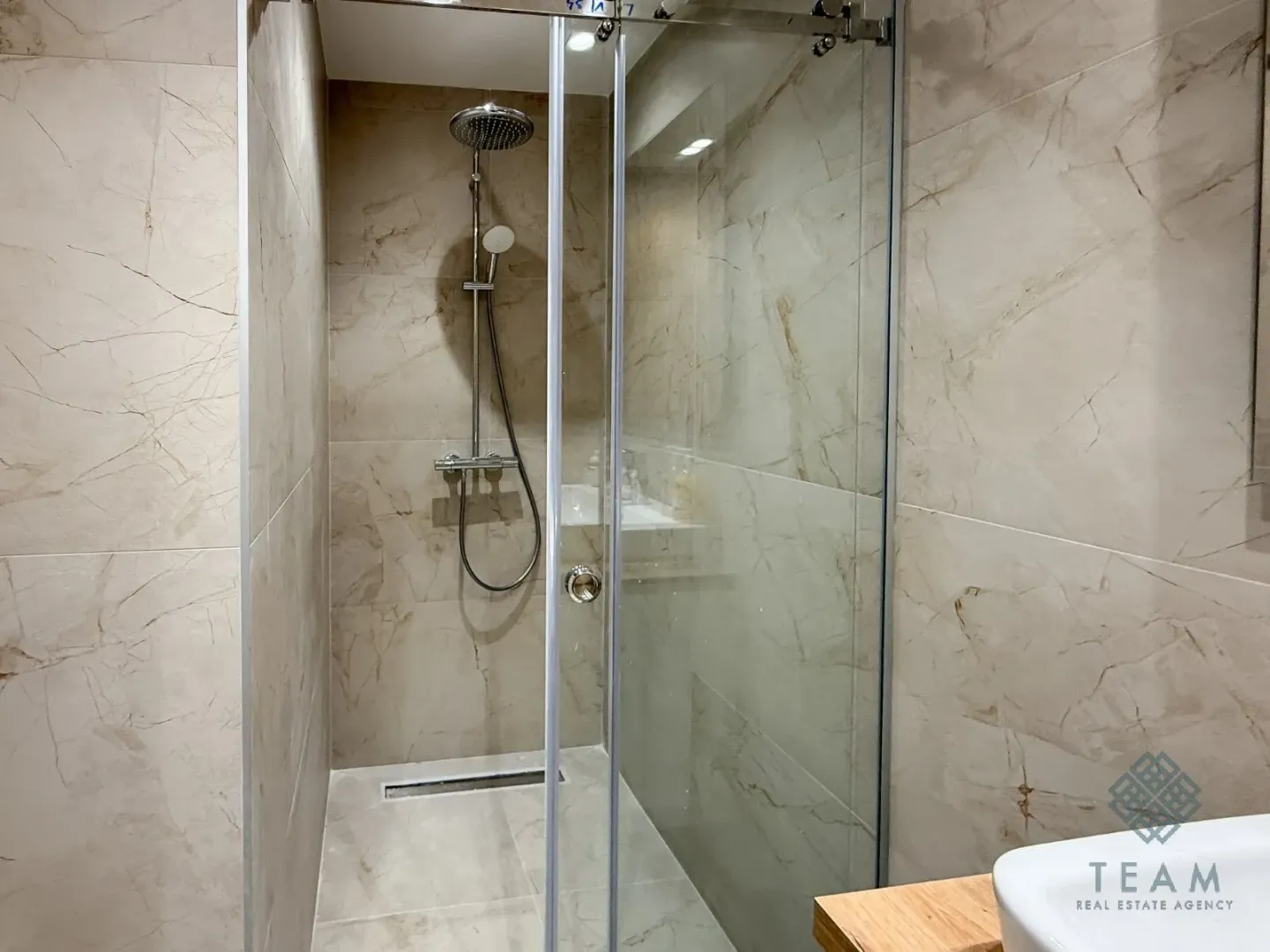 Modern bathroom with a walk-in shower tiled in marble-effect tiles.