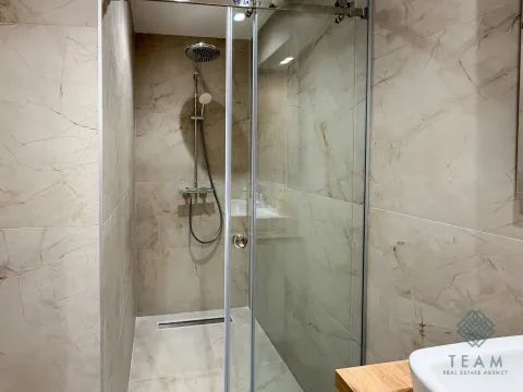 Modern bathroom with a walk-in shower tiled in marble-effect tiles. - image 7