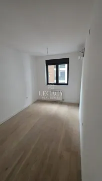 Prazna soba sa belim zidovima, drvenim podom i prozorom. - image 6