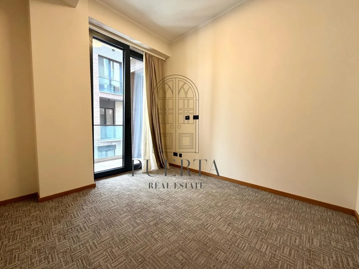 Empty room with carpet and balcony doors.