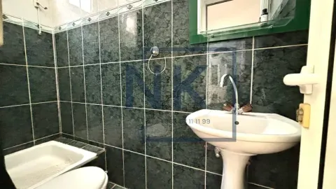 Kupatilo obloženo tamnim pločicama sa umivaonikom i wc šoljom. - image 6