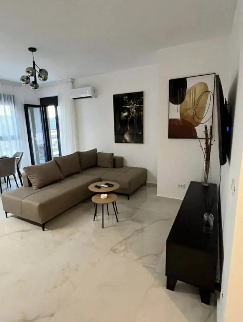 Moderna i svijetla dnevna soba sa ugaonom garniturom.