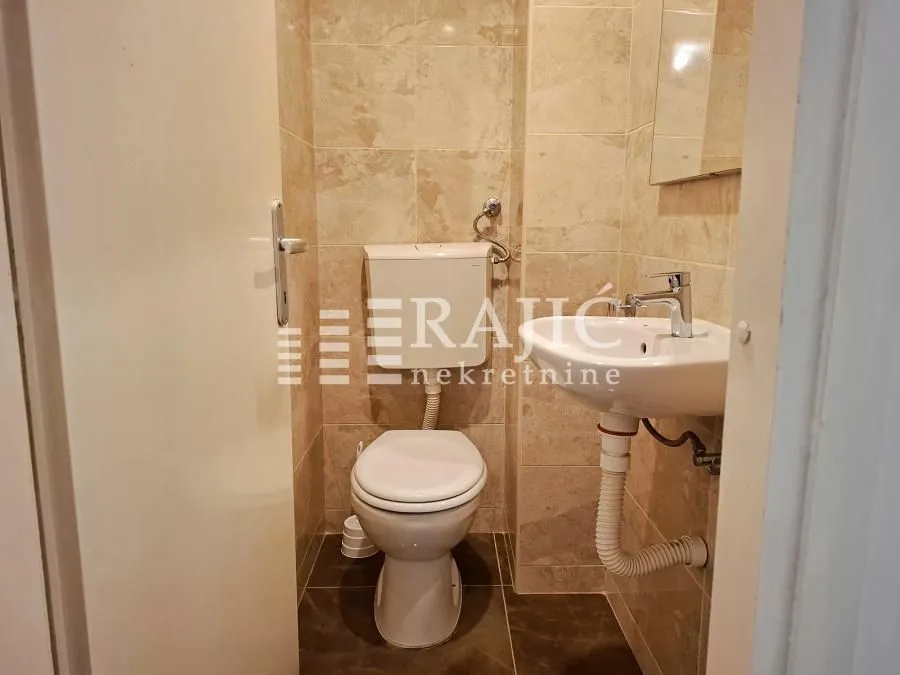 Smaller tiled bathroom with a toilet and a washbasin.