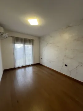 An empty room featuring wooden floors and a marble-texture accent wall. - image 5