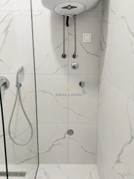 Pogled na moderno opremljen tuš sa bijelim keramičkim pločicama sa mermernom šarom. - image 9