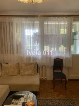 Deo dnevne sobe sa garniturom i prozorom sa zavesama. - image 5