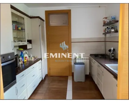 Smaller kitchen with white cabinets and a wooden countertop. - image 4