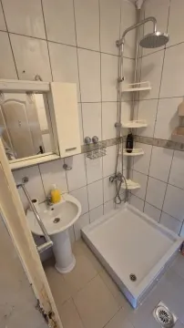 Bathroom equipped with a shower cabin, washbasin, and a mirrored cabinet. - image 8
