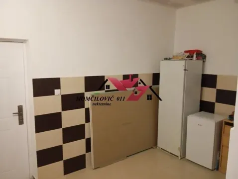 Small kitchen with checkered tiles and a refrigerator. - image 7