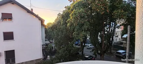 View from the terrace towards the neighbouring building and green trees. - image 10