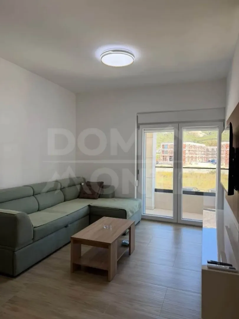 Living room with a sectional sofa, coffee table, and access to the terrace.