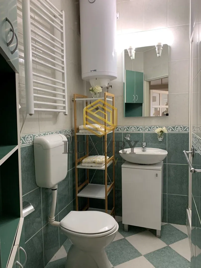 Manje kupatilo sa sanitarijama, tuš kabinom i bojlerom.