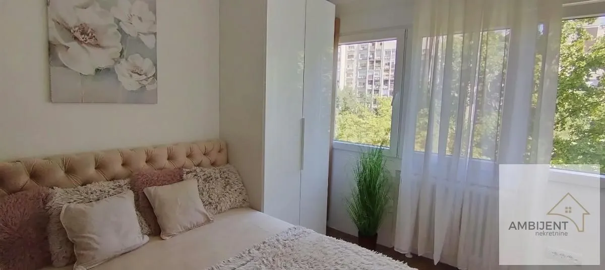 Furnished bedroom with a double bed, wardrobe, and a window with a view.