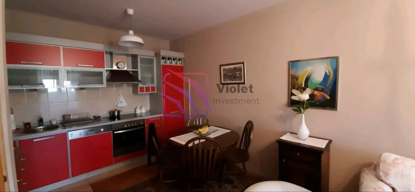 Kitchen with red cabinetry and a dining table with chairs.