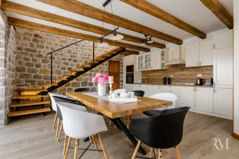 Spacious living room with dining area, wooden beams and a stone wall. - image 6