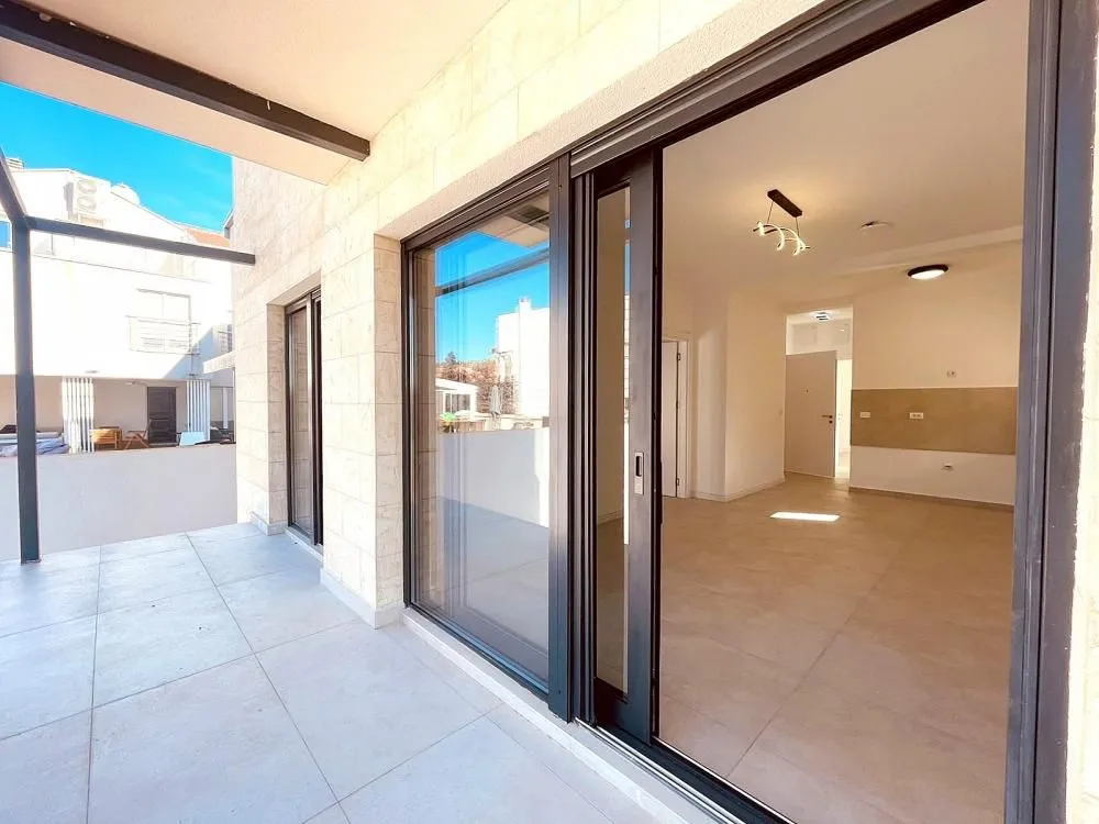 Covered terrace overlooking the courtyard with sliding glass doors leading to the interior.