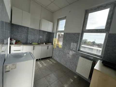 Small kitchen with white cabinets and tiled walls. - image 8