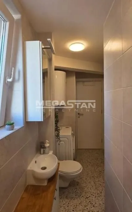 Kompaktno kupatilo sa umivaonikom, WC šoljom i veš mašinom.