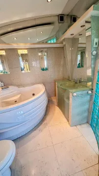 Bathroom equipped with a corner whirlpool bathtub and a sink. - image 10