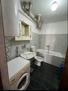 Smaller equipped bathroom with a bathtub, sink, and washing machine. - image 6