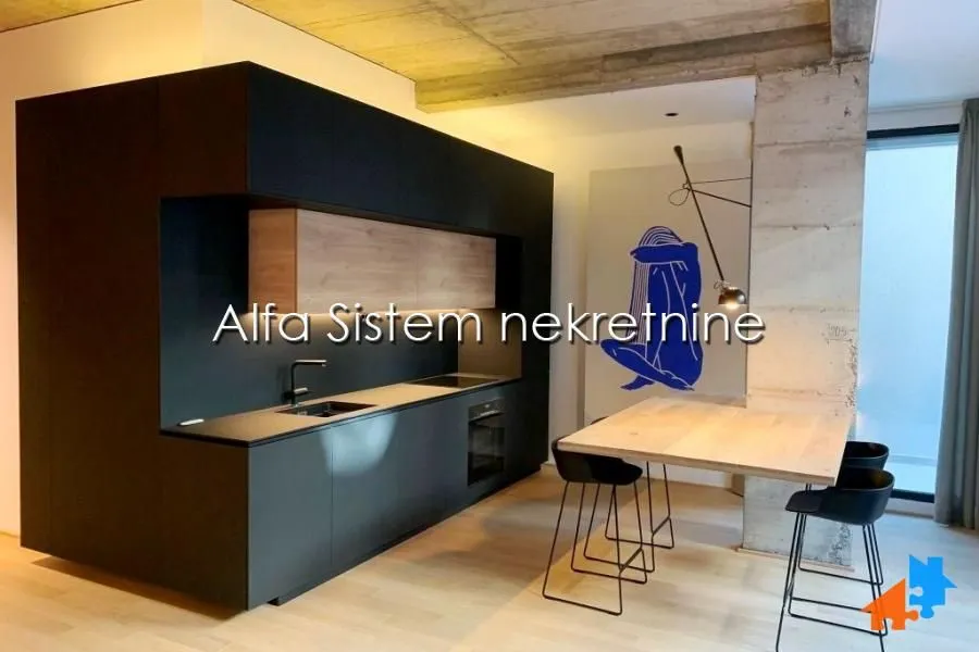 Modern black kitchen with a dining table and chairs.