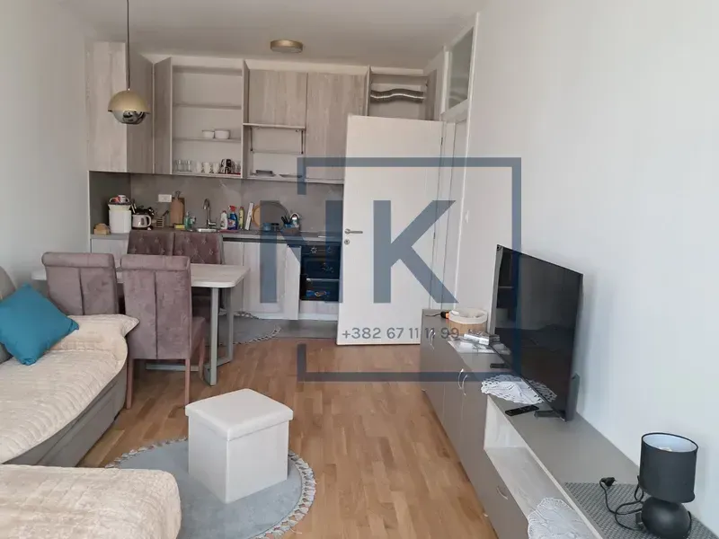 Living room with dining area and kitchen in an open space.