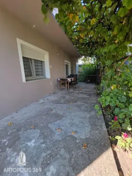 Paved house yard with grapevine shade and a seating table. - image 20