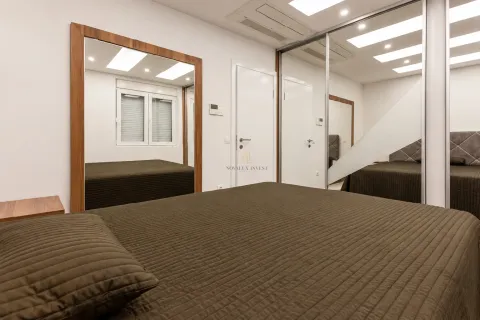 Modern bedroom with a double bed, large mirror, and fitted wardrobe. - image 12