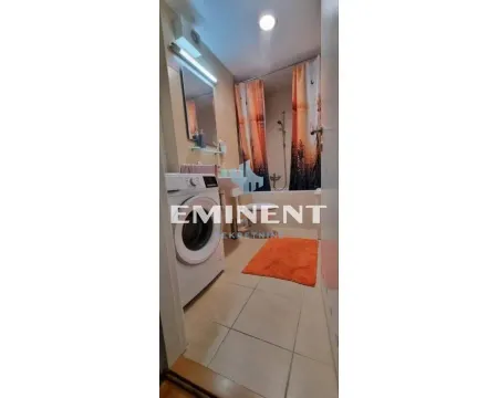 Bathroom with a bathtub, washbasin, mirror, and washing machine. - image 10